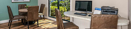 a living room with a desk and a window