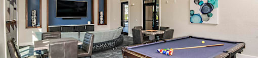 a game room with a pool table and a tv