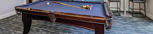 a games room with a pool table and a chandelier