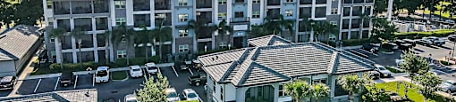an aerial view of a building with cars parked in a parking lot