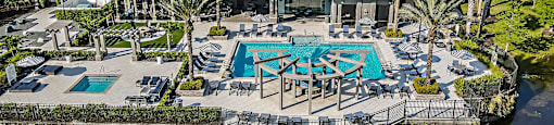 a mansion with a swimming pool and patio furniture on the water