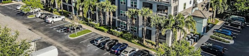 an aerial view of a building with cars parked in a parking lot
