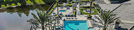 an aerial view of a swimming pool and patio with umbrellas