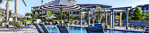 a swimming pool with lounge chairs and an umbrella