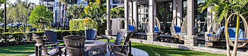 a patio with chairs and a fire pit