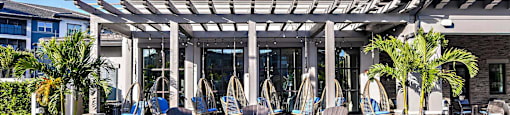 a patio with rocking chairs and a pergola