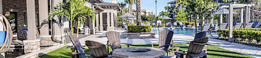 a patio with tables and chairs next to a pool