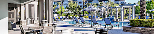 a patio with tables and chairs and a swimming pool