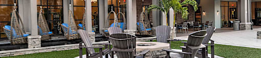 a patio with chairs and tables and a sunset in the background