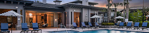 a large swimming pool with a house in the background