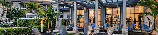 a patio with chairs and a fire pit