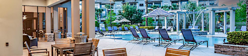a patio with tables and chairs and a swimming pool