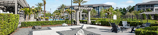 A park with a gravel area, a bench, and a lamp post.