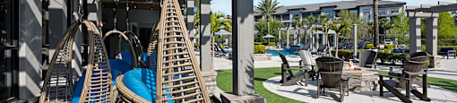 A patio area with blue chairs and a wooden pergola.