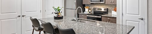 A kitchen with a granite countertop and modern appliances.
