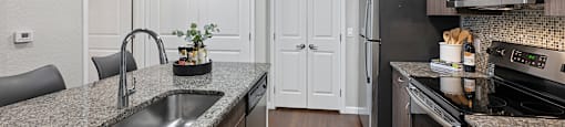 A kitchen with granite countertops and stainless steel appliances.