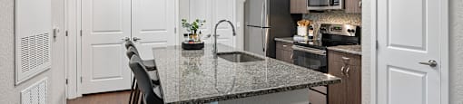 A kitchen with a granite countertop and a sink.