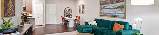A living room with a green couch and a ceiling fan.