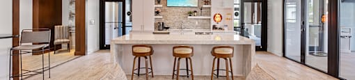A modern kitchen with a bar stool and a couch.
