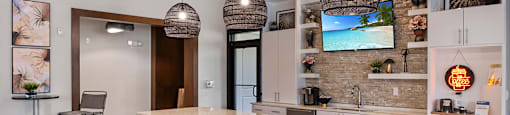 A kitchen with a bar area and a TV mounted on the wall.