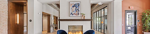A living room with a fireplace and a large grey sofa.