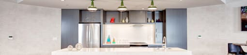 A modern kitchen with a white island and stools.