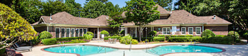 a swimming pool with a house in the background