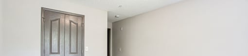 a bedroom with a door and a carpeted floor