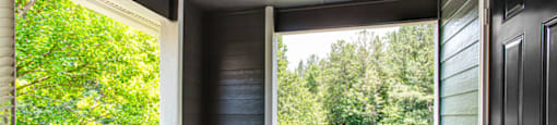 a balcony with a door and a view of a wooded area