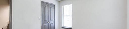an empty room with a door and a window