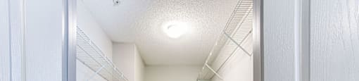 a walk in closet with white walls and a white ceiling