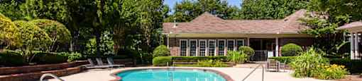 a swimming pool with a house in the background