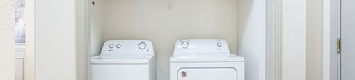 a small laundry room with a washer and dryer and a shelf above the washer