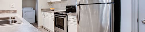 a kitchen with white cabinets and stainless steel appliances