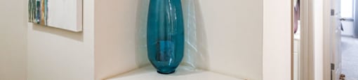 a blue vase sitting on top of a white shelf