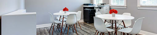 a dining room with a table and chairs and a television on the wall