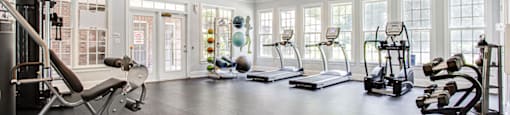 a home gym with exercise equipment and windows