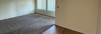A room with a ceiling fan and a window with blinds.