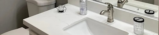 A bathroom with a white sink and a white toilet.