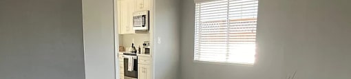 A room with a wooden floor and a doorway leading to another room.