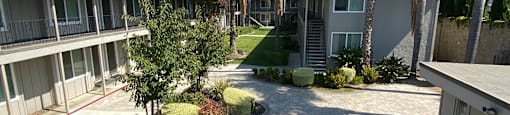 a view of the courtyard of a condo building with palm trees