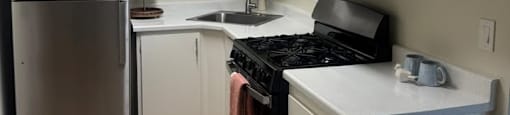 A kitchen with a refrigerator, stove, and microwave.
