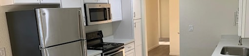 A kitchen with white cabinets and a stainless steel refrigerator.