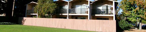 The backside of the Aegena townhomes facing a green lawn and fenced in patios Prodesse Property Group 1211 Garbo Way  San Jose, CA 95117