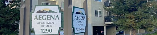 an apartment building with two signs in front of it