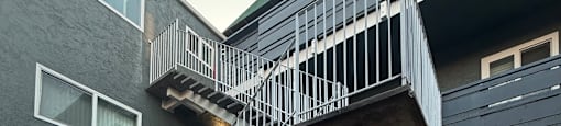 A staircase with a metal railing leads up to a building.