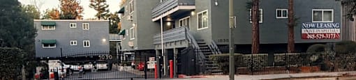 A building with a sign that says "Now Leasing" on it.