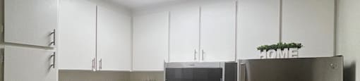 A kitchen with a refrigerator, oven, and sink.