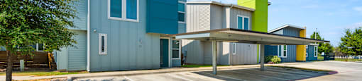 A modern building with a parking lot in front.