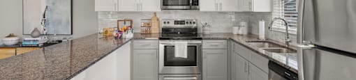 A modern kitchen with stainless steel appliances and white cabinets.
